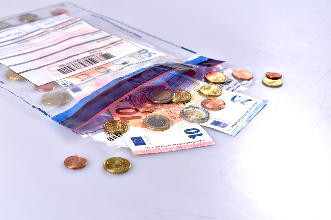 Eine Tüte mit Euro-Münzen liegt auf einem Tisch.